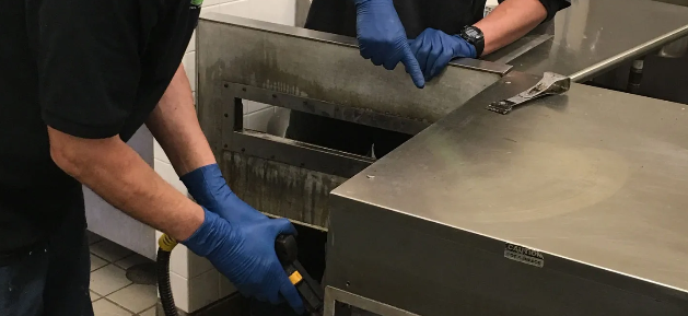 Spotless commercial kitchen with stainless steel equipment and hanging utensils
